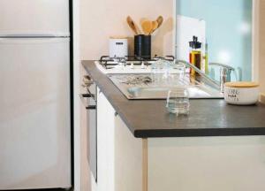 a kitchen counter with a sink and a refrigerator at ZEcamping chiens acceptés espace aquatique et bar in La Baule
