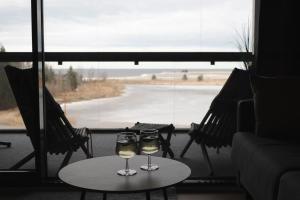two glasses of wine on a table in front of a window at Marinan Portin Svingi A23 lemmikit sallittu in Kalajoki