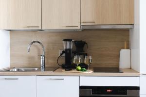 a kitchen counter with a coffee maker and glasses at Marinan Portin Svingi A23 lemmikit sallittu in Kalajoki