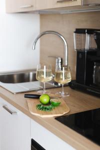 a kitchen counter with two glasses of wine and a cutting board at Marinan Portin Svingi A23 lemmikit sallittu in Kalajoki