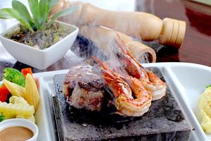 a plate of food with shrimp and vegetables on a table at Alpa City Suites Hotel in Cebu City