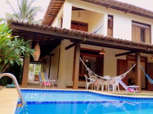 een villa met een zwembad en een huis bij Casa Sapoti - 5 minutos a pé da praia in Praia do Forte