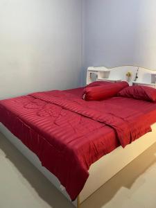a bed with a red blanket on top of it at Kubu home stay in Ban Ko Sawat