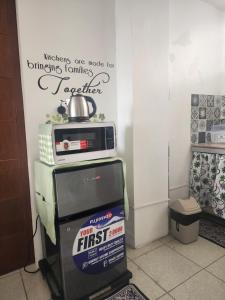a microwave on top of a refrigerator in a room at Caishen Apartelle 301 in Silang