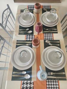 a table with white plates and utensils on it at Caishen Apartelle 301 in Silang