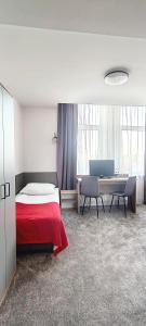 a bedroom with a bed and a desk and a table at Noclegi Sezam in Łańcut