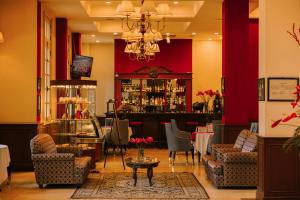a room with a bar with chairs and a table at Du Parc Hotel Dalat in Da Lat