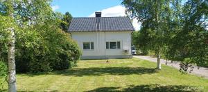 a house in the middle of a yard with trees at Veteli in Veteli