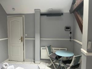 a room with a table and chairs and a door at Nid Parisien in Cachan