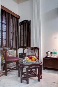 a room with two chairs and a table with fruit on it at Hotel Royal Prithvi Palace Near Ghaziabad Railway Station in Ghaziabad