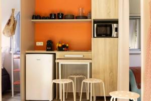 a small kitchen with stools and a microwave at ZEcamping 3 animaux acceptés piscine et restaurant in Saintes