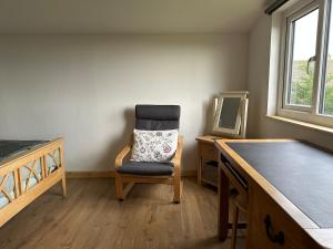 a chair in a room with a desk and a mirror at The Apple Press in Williton