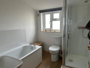 a bathroom with a tub and a toilet and a window at The Apple Press in Williton +22 photos