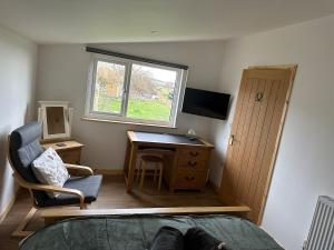 a bedroom with a desk and a bed and a window at The Apple Press in Williton