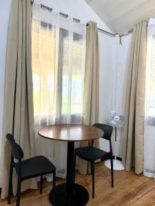 a table and chairs in a room with a window at Namastay Siargao in General Luna