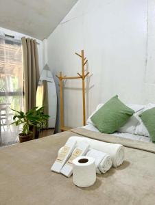 a bedroom with a bed with towels on it at Namastay Siargao in General Luna