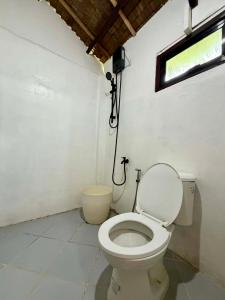 a bathroom with a toilet and a window at Namastay Siargao in General Luna