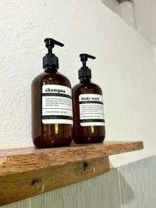 two bottles of shampoo sitting on a wooden shelf at Namastay Siargao in General Luna +10 photos
