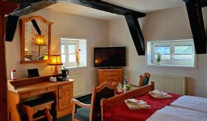 a bedroom with a bed and a desk and a mirror at Hotel Am Markt & Brauhaus Stadtkrug in Ueckermünde