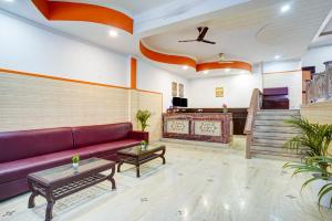 a living room with a purple couch and a piano at Hotel Royal Prithvi Palace Near Ghaziabad Railway Station in Ghaziabad