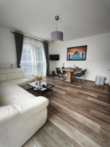 a living room with a white couch and a table at Juliusruh Strandparadies 1 in Juliusruh