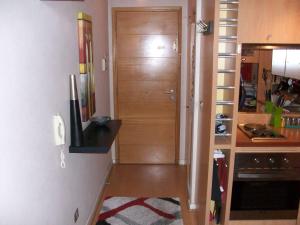 pasillo con puerta de madera en la cocina en Departamento Hernan, en Viña del Mar