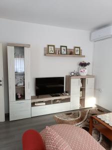 a living room with a television in a white entertainment center at Apartman Centar in Modriča