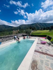 a group of people in a swimming pool with mountains in the background at Santuyoc in Volcán