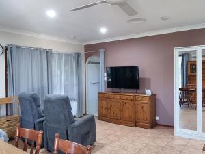 a living room with two chairs and a flat screen tv at Theme Park Getaway in Gold Coast
