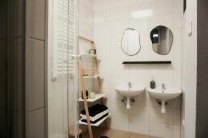 a white bathroom with two sinks and a mirror at Nowoczesny Apartament w Prudniku in Prudnik