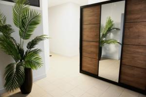 a bathroom with a mirror and a plant in aoyer at Nowoczesny Apartament w Prudniku in Prudnik