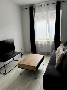 a living room with a couch and a coffee table at Nowoczesny Apartament w Prudniku in Prudnik +5 photos