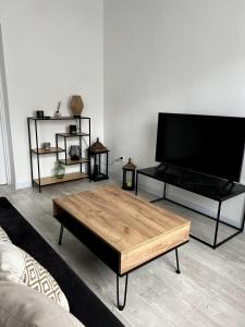 a living room with a tv and a coffee table at Nowoczesny Apartament w Prudniku in Prudnik