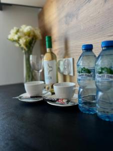 a table with two bottles of water and two cups at Nowoczesny Apartament w Prudniku in Prudnik