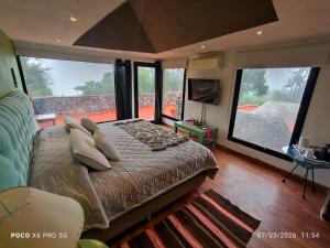 a bedroom with a bed with pillows and a large window at Santuyoc in Volcán