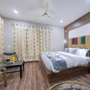 a bedroom with a large bed and a table at Hotel Your Hive in Srinagar +4 photos