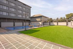 a building with a green lawn in front of a building at Hill Berry - A SoVo Hotel in Lonavala