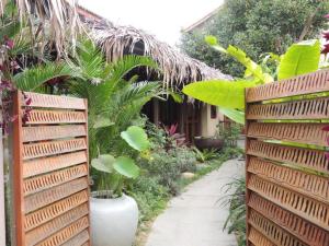 a garden with a wooden fence and plants at Anicca Riverside Cottage in Thanh Ðông (1)