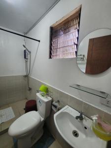 a bathroom with a toilet and a sink and a mirror at Caishen Apartelle The Couples Getaway in Silang