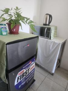 a tv sitting next to a table with a microwave at Caishen Apartelle The Couples Getaway in Silang