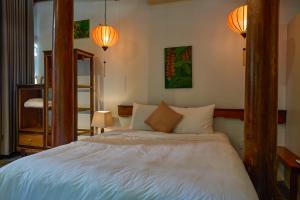 a bedroom with a bed and two lamps and a ladder at Anicca Riverside Cottage in Thanh Ðông (1)