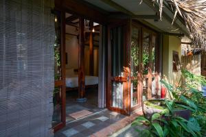 an entrance to a house with a glass door at Anicca Riverside Cottage in Thanh Ðông (1) +9 photos