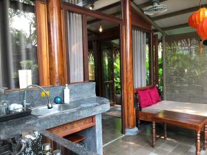 a kitchen with a sink and a table and a bench at Anicca Riverside Cottage in Thanh Ðông (1)