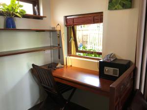 a wooden desk with a microwave and a window at Anicca Riverside Cottage in Thanh Ðông (1)