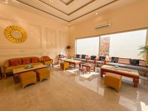 a living room with couches and tables and a large window at Corbett The Regnum Resort in Rāmnagar