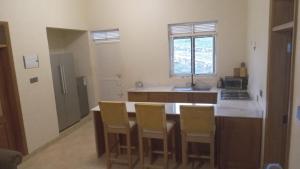 a kitchen with a counter with chairs around it at Marakunda - Victoria in Jinja