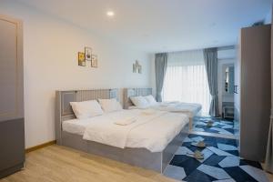 two beds in a hotel room with shoes on the floor at Vera Cozy Stay 2 in Ban Zong Katiam