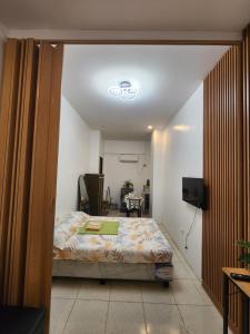 a bedroom with a bed and a tv in a room at Caishen Apartelle The Couples Getaway in Silang