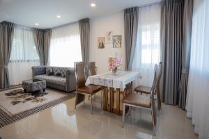 a living room with a table and chairs and a couch at Vera Cozy Stay 2 in Ban Zong Katiam
