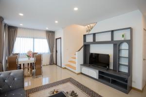 a living room with a large television and a couch at Vera Cozy Stay 2 in Ban Zong Katiam